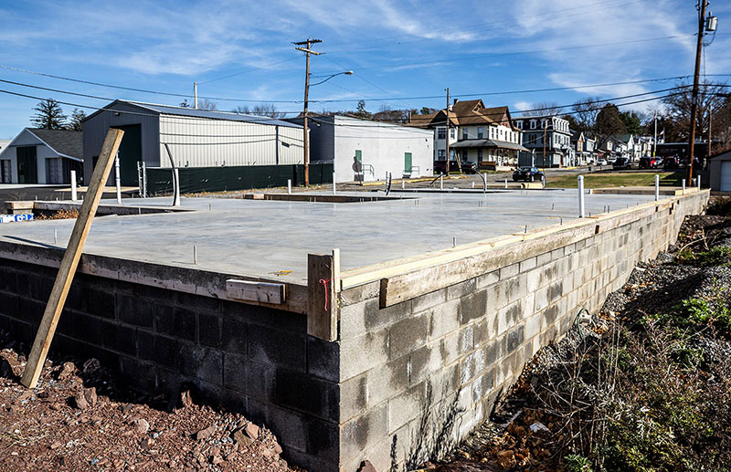 Vacant Development Site in Halifax, Dauphin County Concrete foundation of a construction site in Halifax, Dauphin County, with nearby homes and buildings